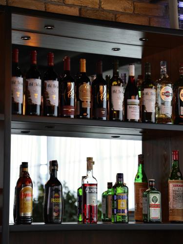 a shelf filled with lots of bottles of alcohol at Praga Hotel in Tashkent