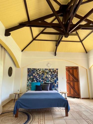 a bedroom with a blue bed in a room at Kaz' Évasion plage & jacuzzi - REMIRE-MONTJOLY in Montjoly