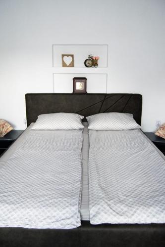 two beds in a bedroom with white walls at Aranyos vendégház in Cristuru Secuiesc
