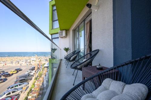a balcony with chairs and a view of the beach at V&T Residence Mamaia Nord in Mamaia Sat/Năvodari