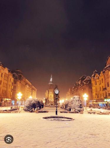 a clock tower in the middle of a city at night at Apartament Lux Crialy - 75 m2 - free parking in Timişoara