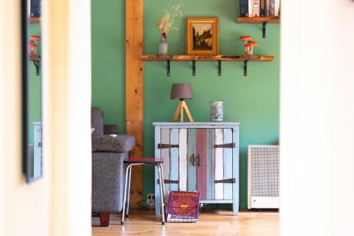 a room with green walls and a table with a lamp at Cozy Tiny House between Veluwe en Veluwemeer - with free use of bikes in Ermelo