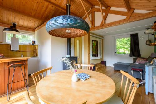 a kitchen and a dining room with a wooden table at Cozy Tiny House between Veluwe en Veluwemeer - with free use of bikes in Ermelo