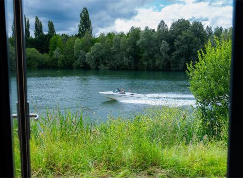 un bateau dans l'eau sur un lac dans l'établissement Ezy House 1 by Tiny Away, à Ézy-sur-Eure
