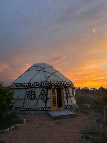 a dome house with a sunset in the background at Guest house and yurt camp Svetlana in Bokonbayevo