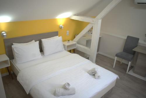 a bedroom with a white bed and a ladder at Vila Storia in Niš