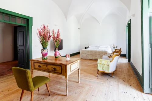 a living room with a table with flowers on it at Amada Moura in Moura