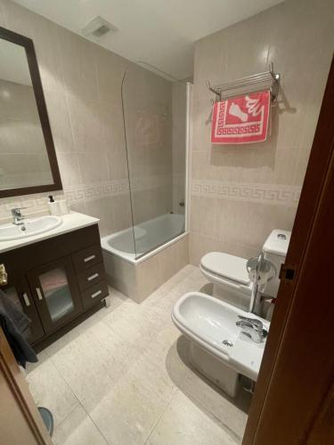 Un baño con lavabo, inodoro y espejo. en Apartamento en Ribeira a 200m de la playa, en Ribeira