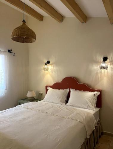 a bedroom with a bed with white sheets and two lights at Merian's House in Fethiye
