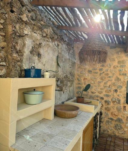 a kitchen with a stone wall with a wooden sink at Merian's House in Fethiye