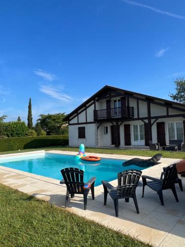 une personne saute dans une piscine dans l'établissement La villa Landaise avec piscine, à Saubrigues