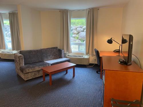 a living room with a couch and a table at Super 8 by Wyndham Sainte Agathe Des Monts in Sainte-Agathe-des-Monts
