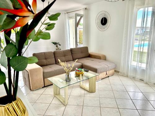 un salon avec un canapé et une table dans l'établissement La villa Landaise avec piscine, à Saubrigues