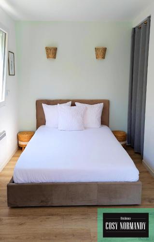 une chambre avec un grand lit avec des draps blancs dans l'établissement Cosy Normandy - 04, à Bois-Jérôme-Saint-Ouen