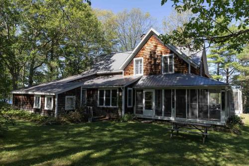 an old house with a gambrel roof on a lawn at Family Cottage Sheep Island in Delta