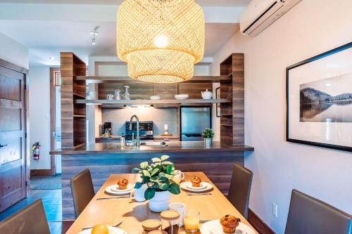 a dining room with a wooden table and a chandelier at Lakefront, Mountain View - 1 Bedroom Resort Suite in Lac-Superieur