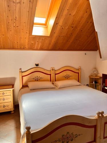 a bedroom with a large bed with a wooden headboard at Hotel & Restaurant AL TRIVIO in Altana