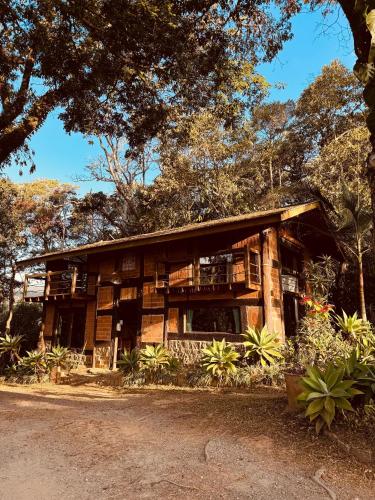 a wooden building with trees in the background at Smart Hotel Reserva Santo Antônio do Pinhal in Santo Antônio do Pinhal