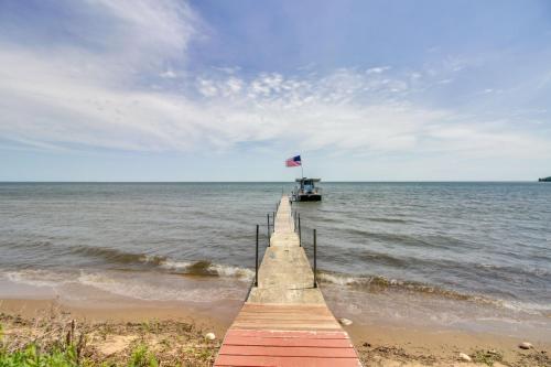 a wooden pier with a flag on the water at Muskie Cabin on Mille Lacs Lake Boat and Fish! in Garrison