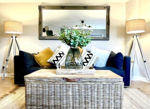 ein Wohnzimmer mit einer Couch und einem Tisch mit einer Blumenvase in der Unterkunft Central Ellesmere -Sleeps2 - Parking - PetFriendly in Ellesmere