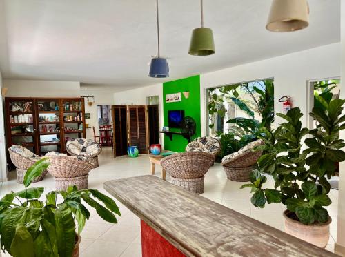 a living room with potted plants and a table at Pousada Baía das Conchas in Ubatuba