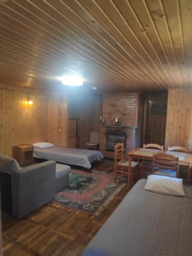 a room with several beds and a couch and a table at White House puhkemaja in Uulu