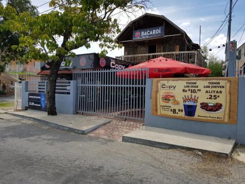 a fence with a sign in front of a restaurant at Charming & Family-Friendly Boqueron Village Condos! in Boqueron