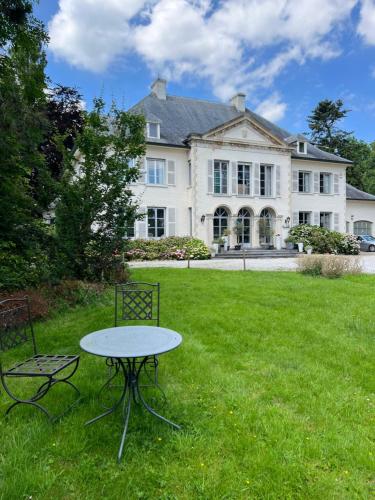 un tavolo e sedie di fronte a una grande casa di Hotel Fleur de Lys a Zedelgem