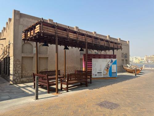 a bus stop with two benches under a canopy at Heritage Home Guest House in Dubai