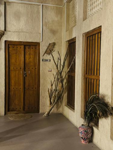 a building with two doors and a plant in a vase at Heritage Home Guest House in Dubai