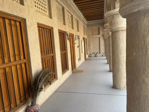 an empty hallway of a building with columns and doors at Heritage Home Guest House in Dubai
