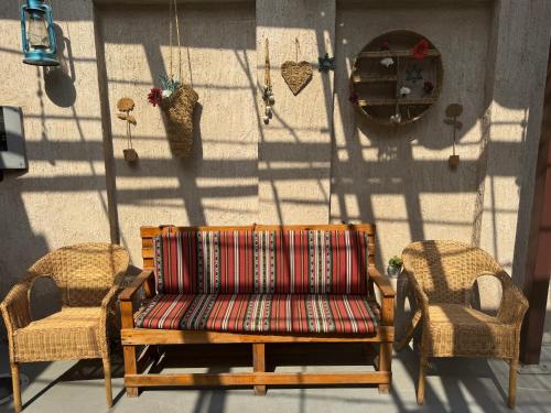 a couch and two wicker chairs on a patio at Heritage Home Guest House in Dubai