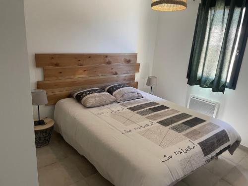 une chambre avec un grand lit avec une tête de lit en bois dans l'établissement Villa bedoin au pied du mont ventoux 4 pers, à Bédoin