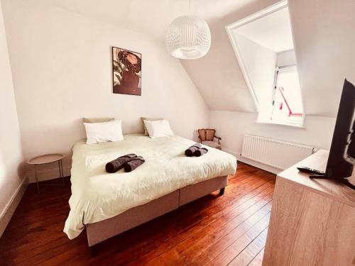 a bedroom with a bed with two bags on it at Villa Léontine Wimereux in Wimereux