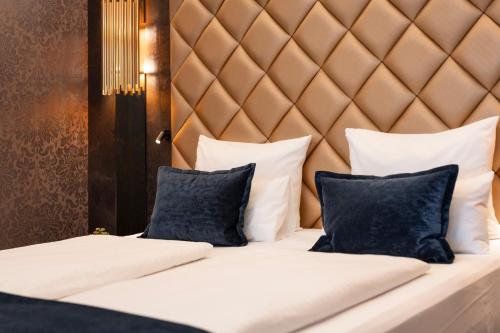 a bed with white pillows and a headboard at Boutique Hotel Germania in Munich