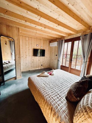 une chambre avec un grand lit dans une pièce aux murs en bois dans l'établissement La Villa Les Inséparables, à Lège-Cap-Ferret