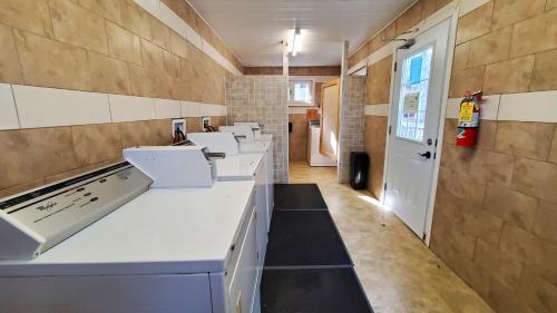 a kitchen with white counters and a row of sinks at Oakhill Pines Campground in Bridgewater