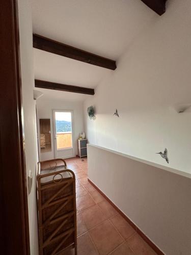 - un couloir d'une maison avec une chambre dotée d'une fenêtre dans l'établissement Appartement MAEVA duplex vue mer à Favone, à Conca