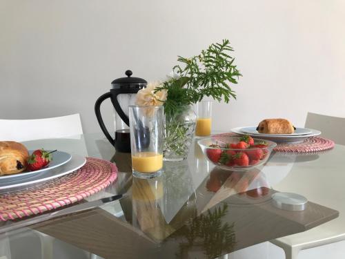 a glass table with a plate of food and a bowl of fruit at Little Pyes barn in Battle