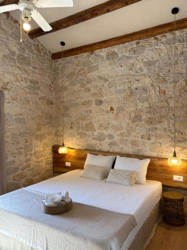 een slaapkamer met een groot bed en een stenen muur bij NEW 2024! Casa Vecchia in Višnjan