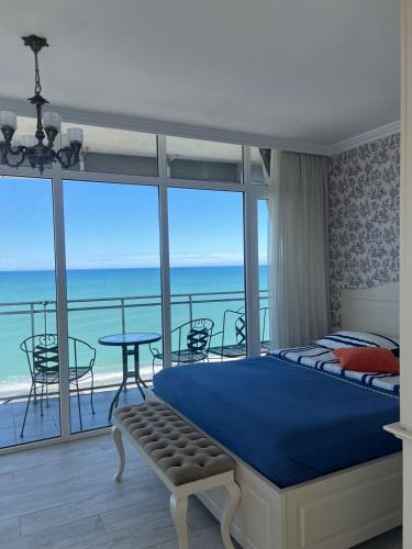 a bedroom with a bed and a view of the ocean at Apartment Batumi Weekend in Batumi