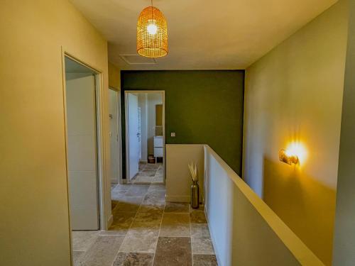 un couloir avec un mur vert et un luminaire dans l'établissement Villa Gabriel, un meublé de tourisme 3 étoiles au cœur de Goult, à Goult