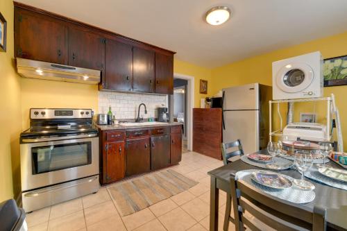 a kitchen with wooden cabinets and a table with plates on it at Renovated Charlotte Bungalow - 3 Mi to Downtown! in Charlotte