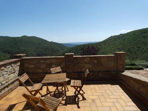 a table and chairs on a patio with mountains in the background at Scappo in Umbria, la Vallata in Parrano