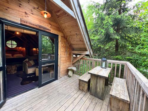 a porch of a wooden cabin with benches on it at Les Cabanes de Rensiwez in Mabompré