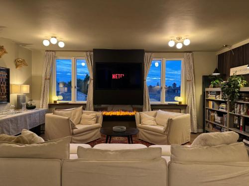 ein Wohnzimmer mit weißen Sofas und einem Fernseher in der Unterkunft Stunning Designer House, Fantastic City Location - Cambridge Homehost in Cambridge