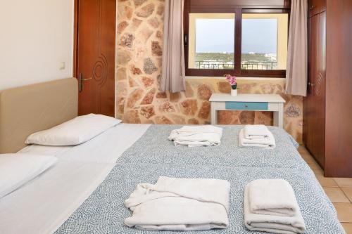 a bedroom with a bed with towels on it at Pasiphae villas 1 & 2 in Stalos