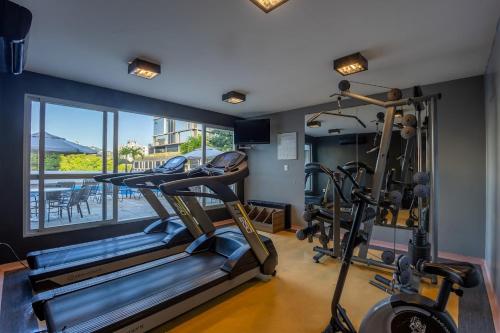 a gym with two tread machines and a window at Plaza Blumenau Hotel in Blumenau