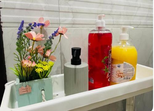 ein Regal mit zwei Flaschen Seife und Blumen in der Unterkunft The Perfect Studio in Abu Dhabi