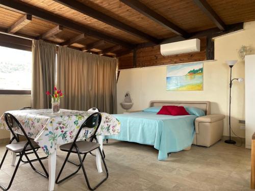 a bedroom with a bed and a table and chairs at Suite de la Sicilienne in Castellammare del Golfo